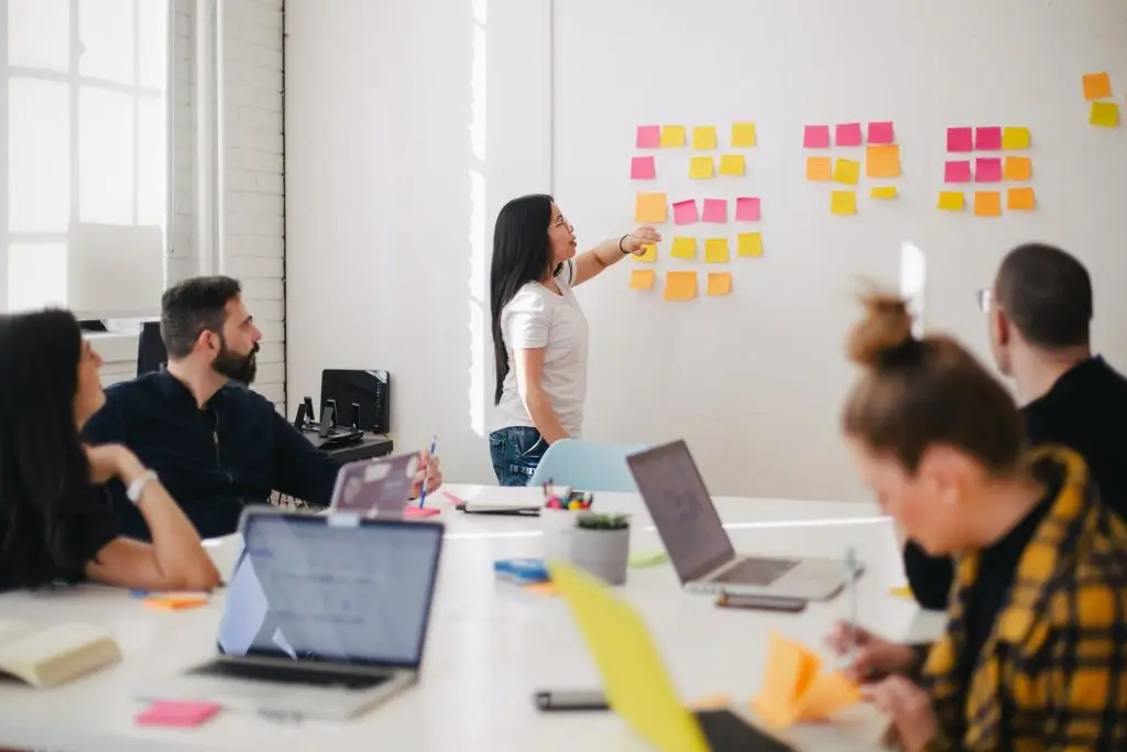 Team brainstorming with sticky notes on board.