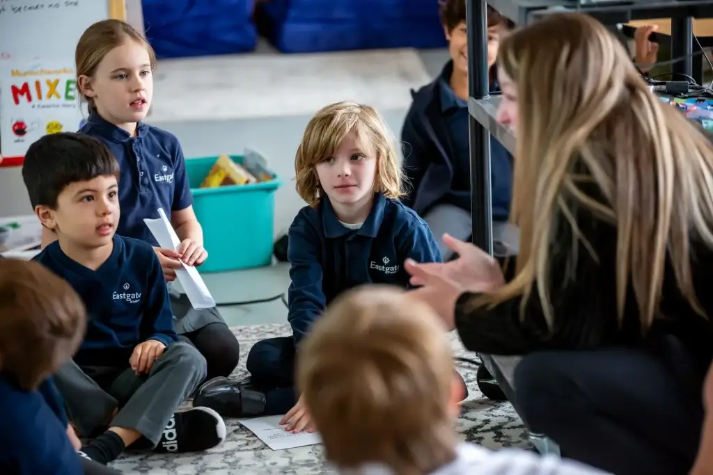 Teacher engaging young students in classroom discussion.