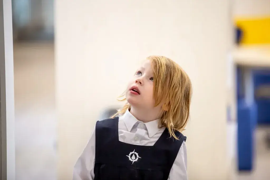Child in uniform looking upwards.